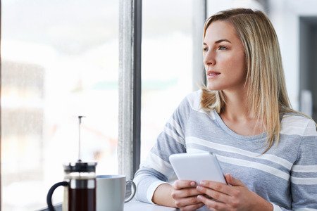 young businesswoman working on tablet computer while drinking coffee in the office